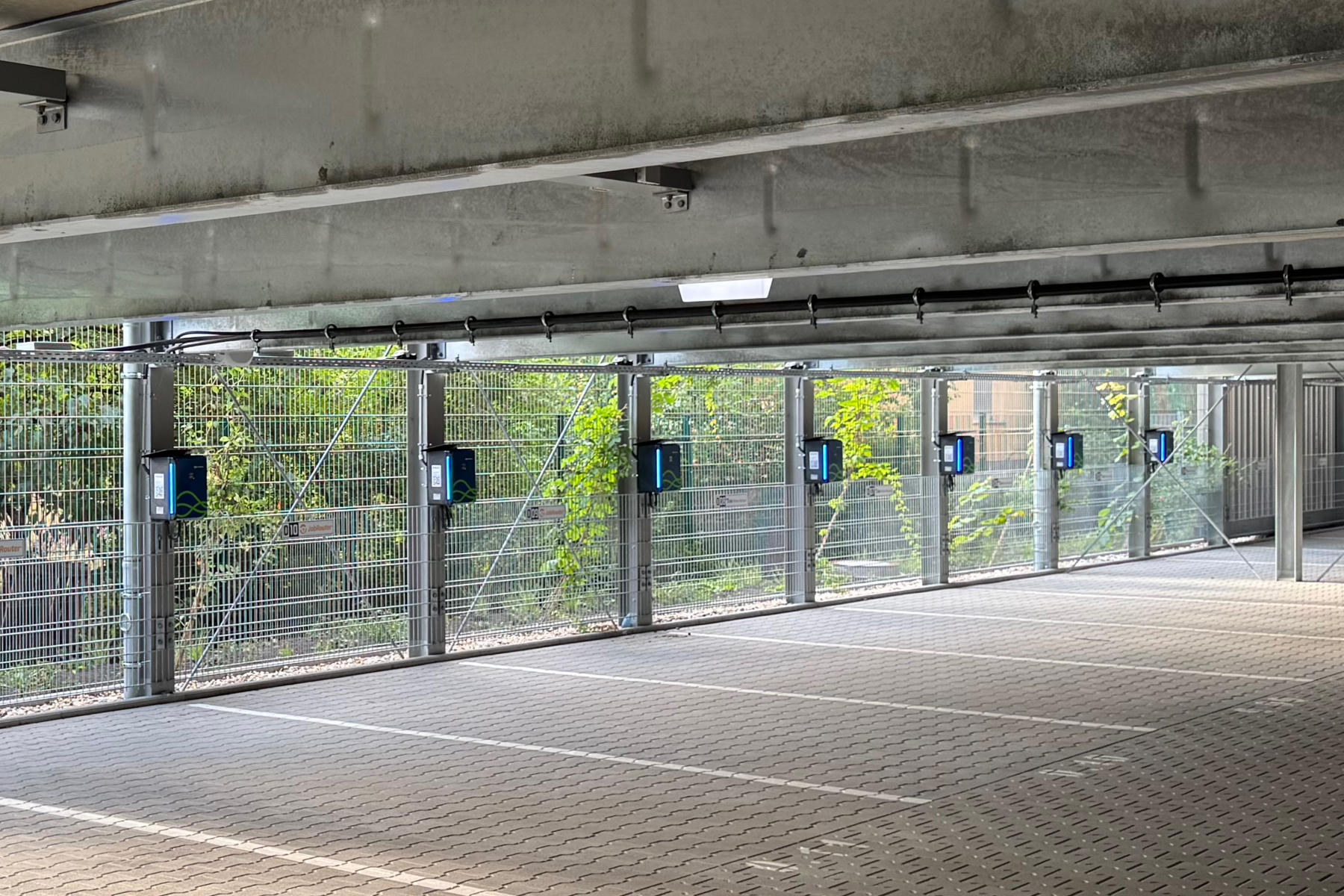 A row of parking spots in a private garage, each equipped with an EV charging station we built